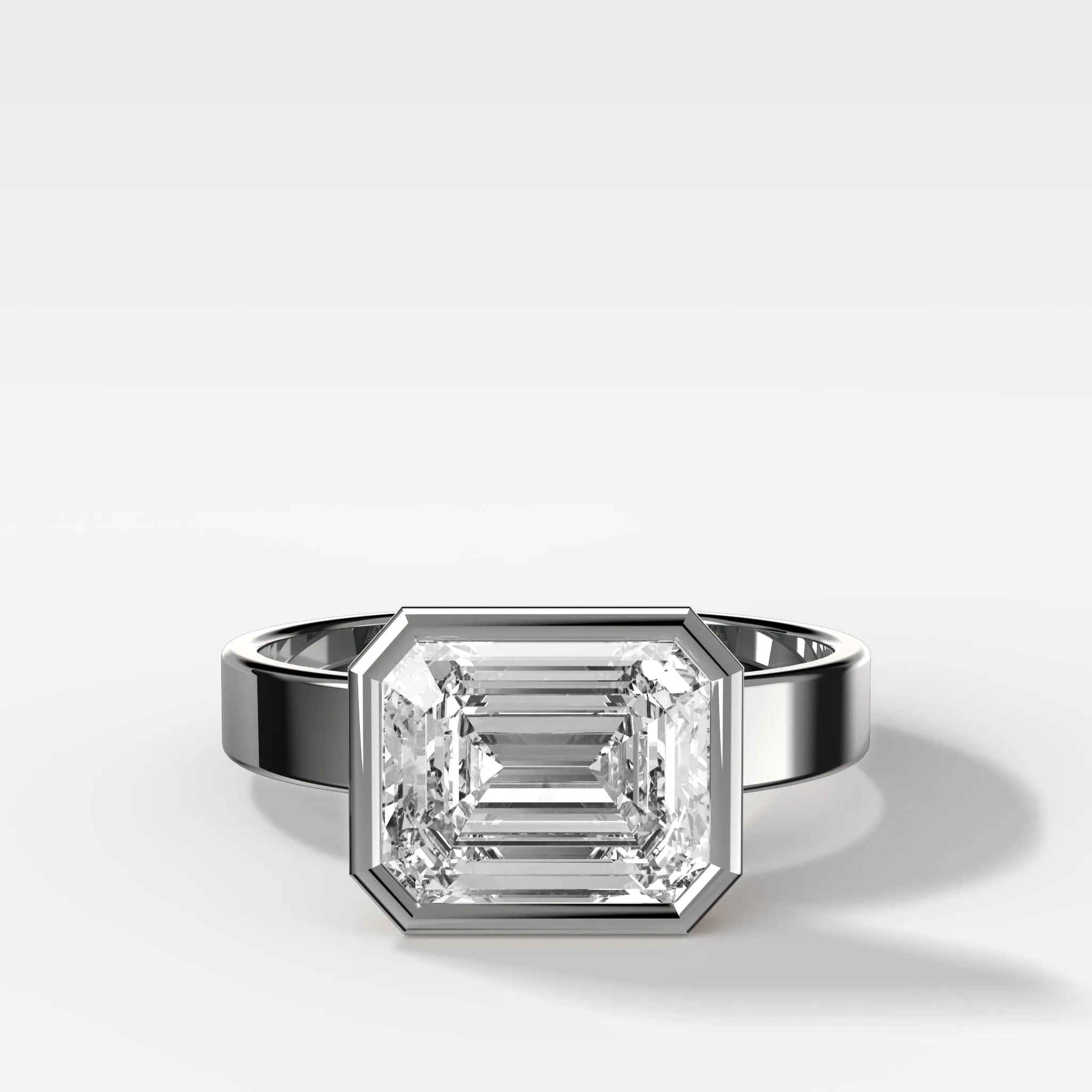 Finest Bezel Set Engagement Ring With East West Emerald Cut Diamond
