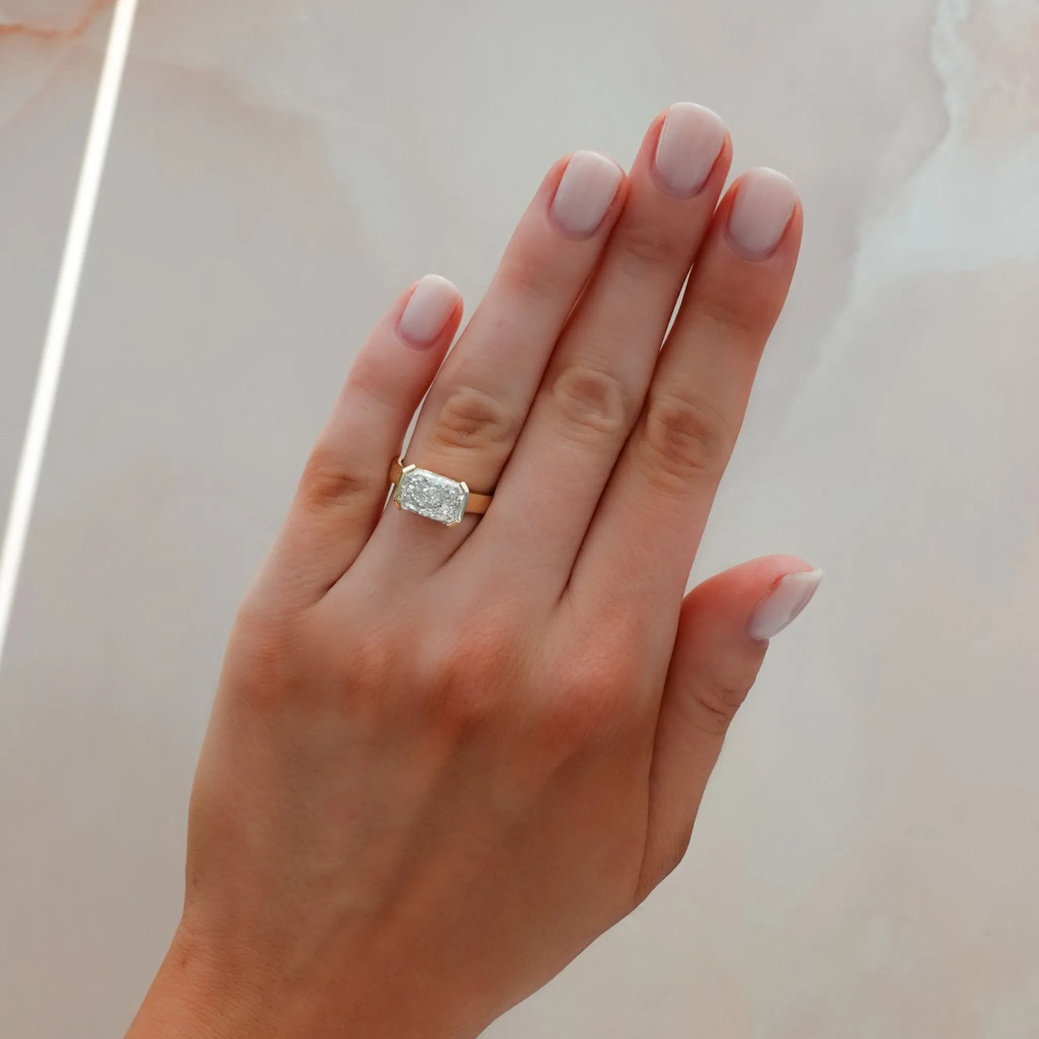 Finest Half Bezel Solitaire Engagement Ring With East West Elongated Radiant Cut Diamond