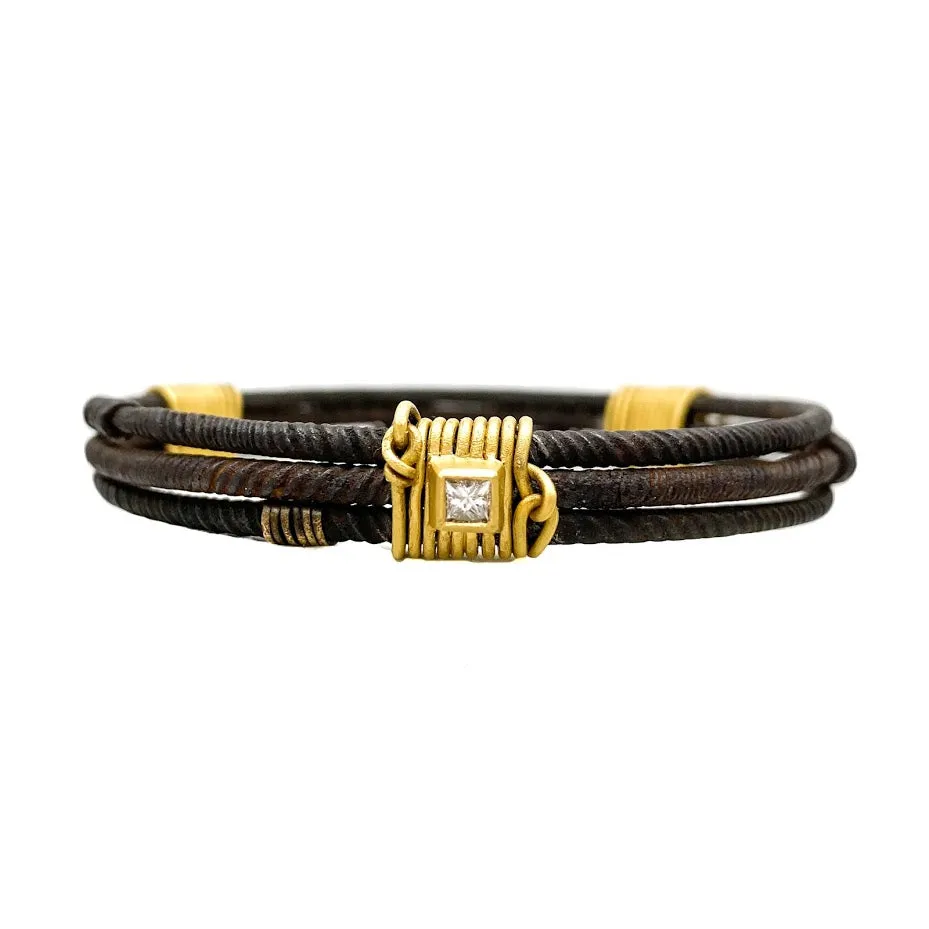 Three old African wrought iron "money" bracelets lashed together with 22K gold wires and set with diamonds