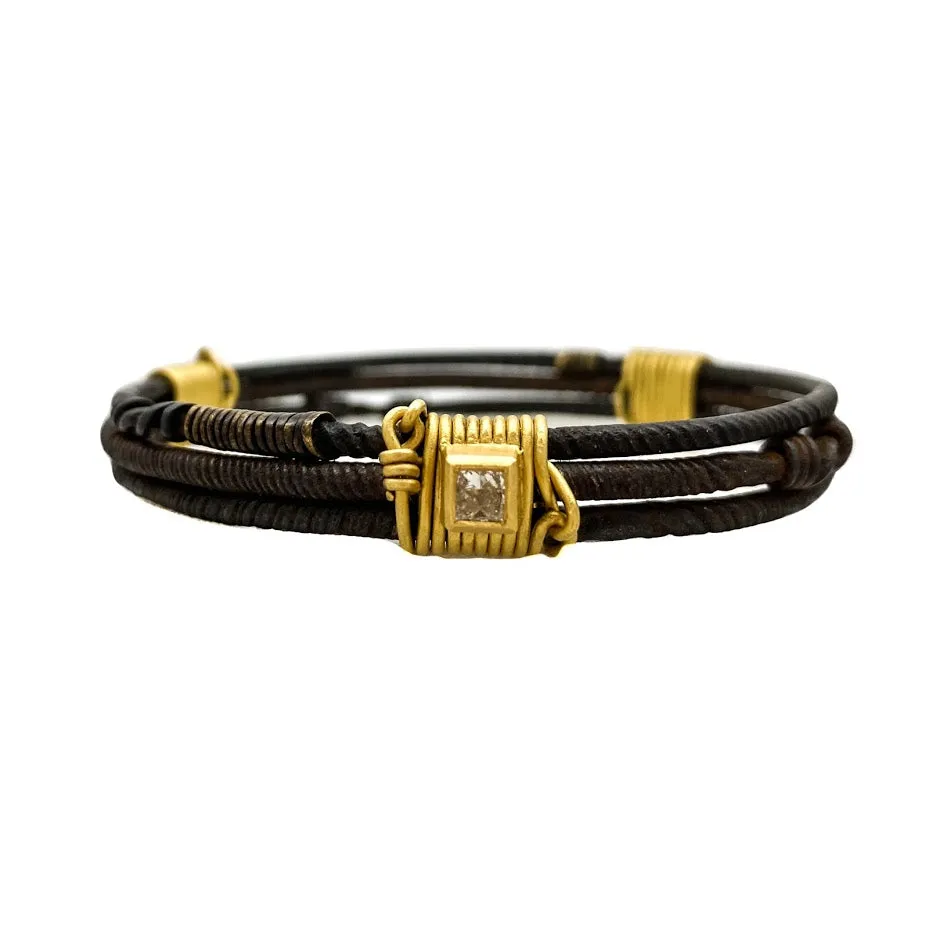 Three old African wrought iron "money" bracelets lashed together with 22K gold wires and set with diamonds